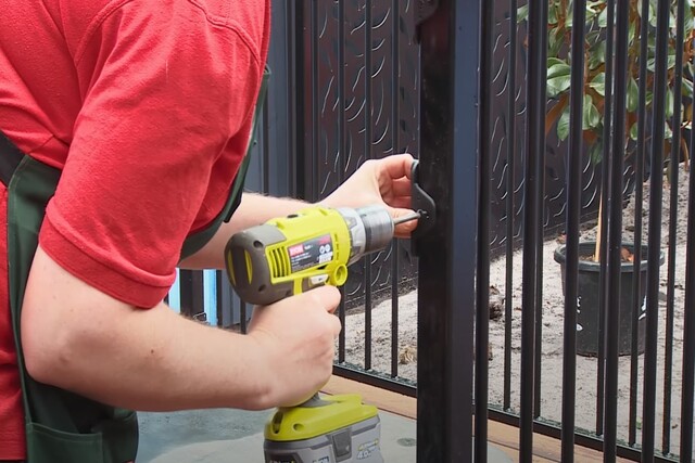 Worker installing an aluminum pool fence