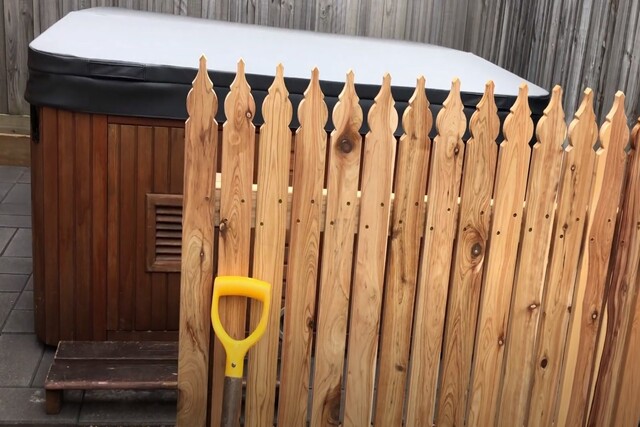 Wood pool fence in front of a hot tub